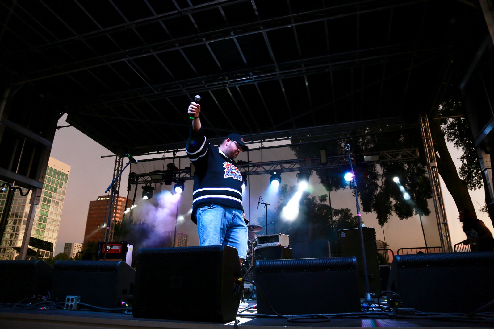Bryan on stage with mic raised at a WJRR outdoor show