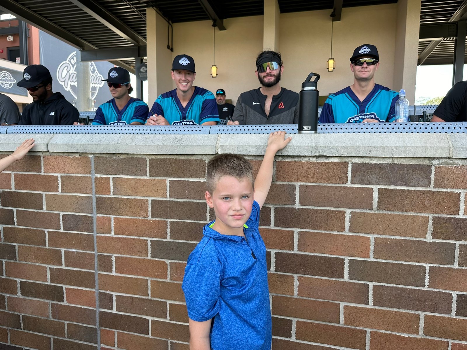Young fan getting autographs from Gastonia players