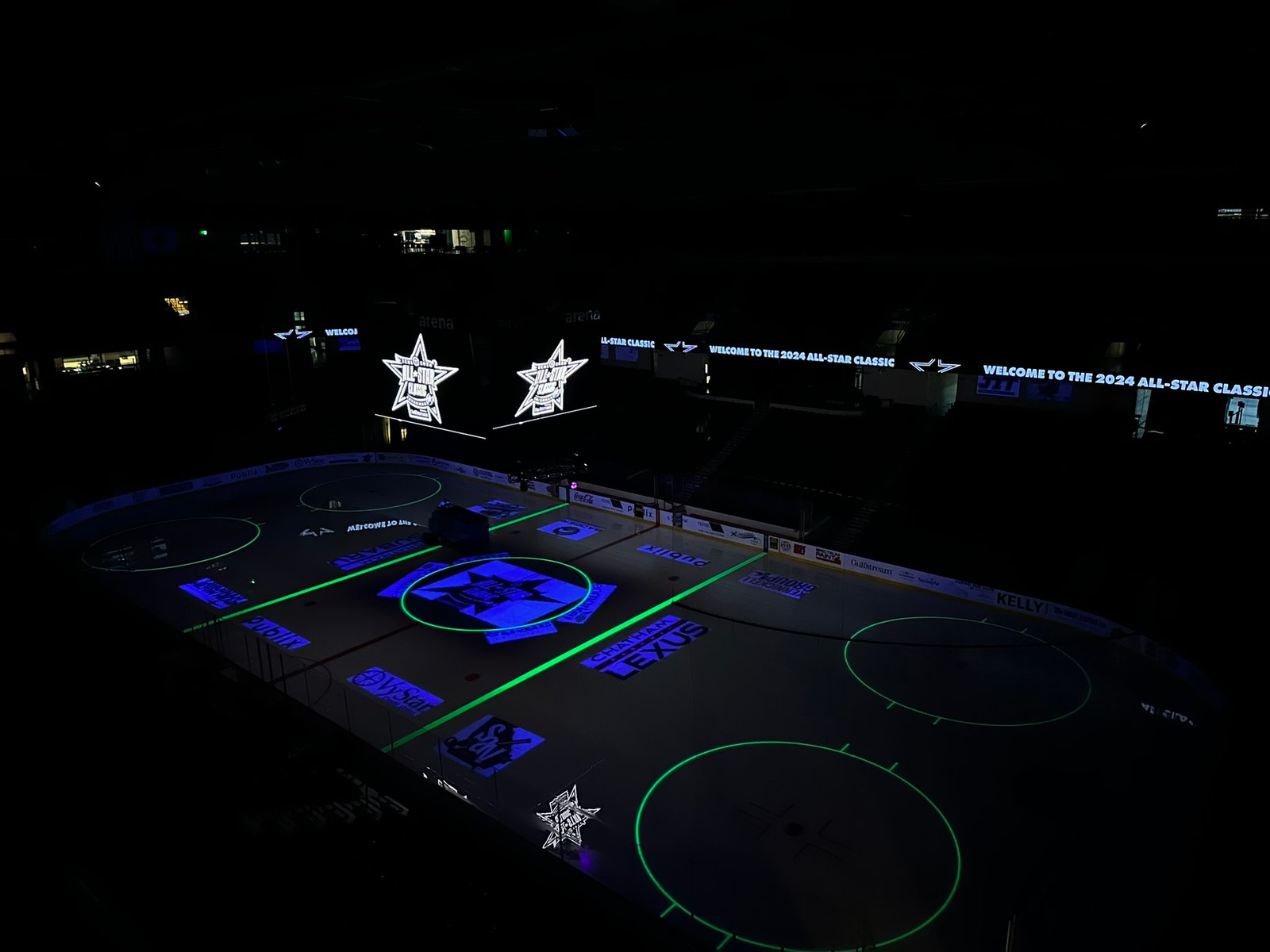 All-Star Classic logos projected on the ice under arena lighting