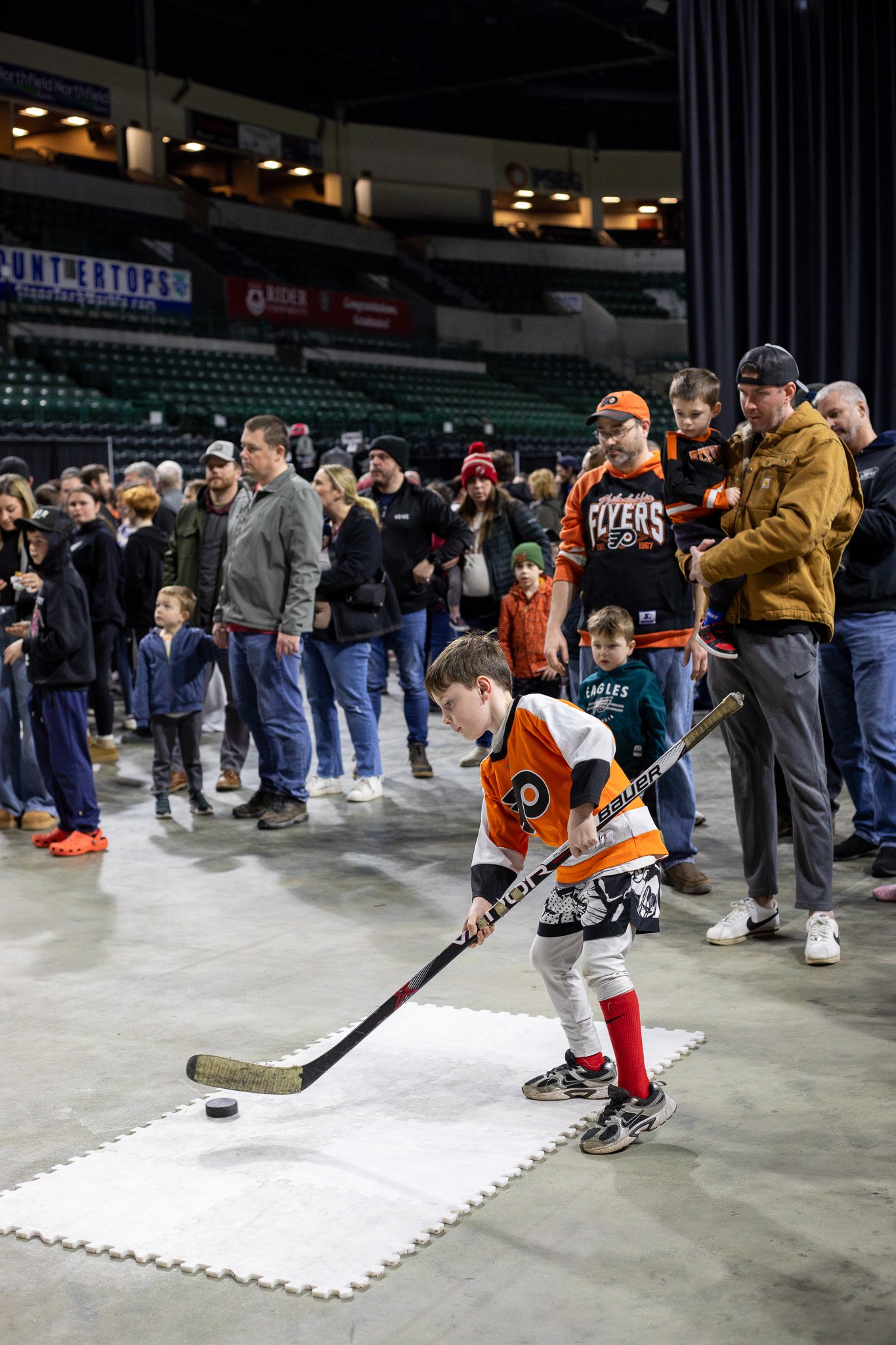 Young fan shooting a puck at the Fan Fest activity station