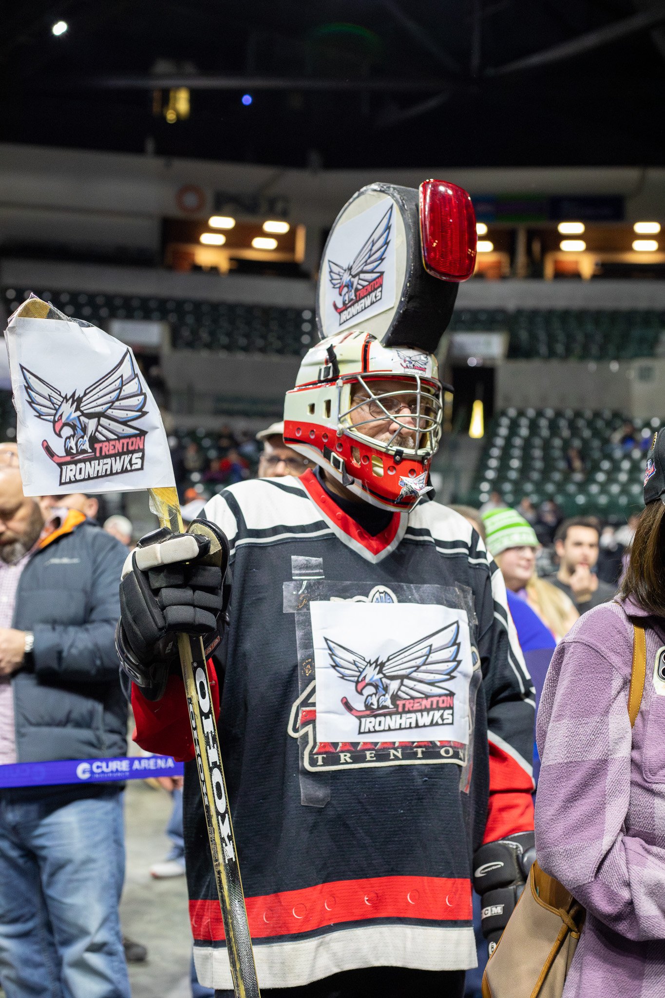 Superfan in a homemade Ironhawks costume holding a team flag